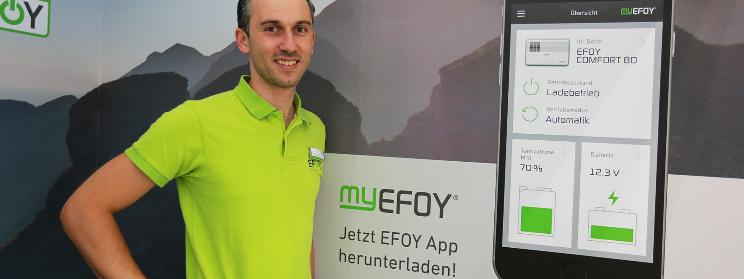 Bilde av mann ved siden av plakat av appen