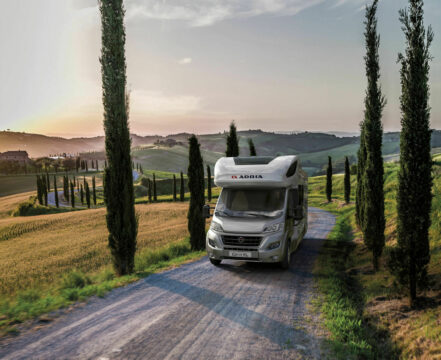 Bobil som kjører på en smal landevei