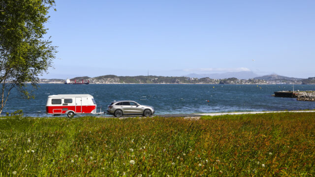 Bil og campingvogn kjører ved havet