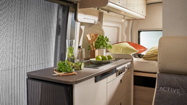 Kompakt kjøkken med kjøleskap, vask og kokemuligheter.